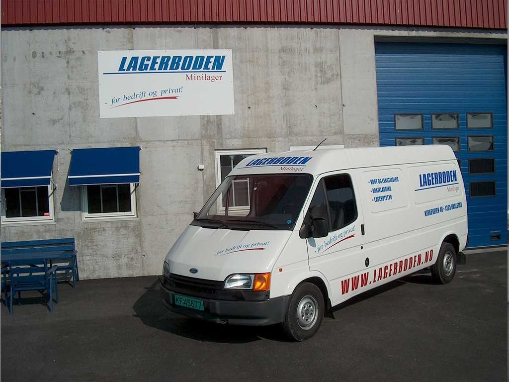 En bygning som har et skilt hvor det står Lagerboden og en hvit firmabil med samme logo på