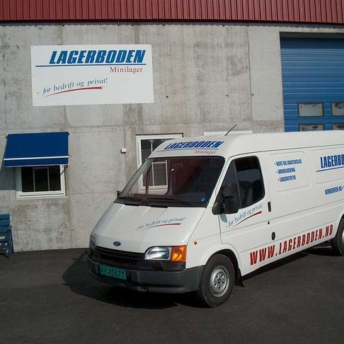 En bygning som har et skilt hvor det står Lagerboden og en hvit firmabil med samme logo på